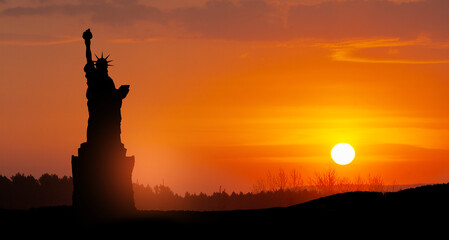 Silhouettes of The Statue of Liberty at sunset. Greeting card for Independence Day. USA celebration.