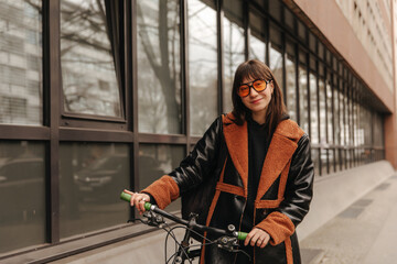 Fototapeta na wymiar Side view of smiling woman with bike look at camera 