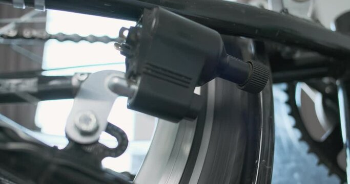 Bicycle dynamo bottle type, does not come into contact with the tire. Rotation of bicycle wheel, side view, close-up.