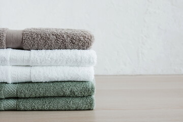 Obraz na płótnie Canvas Stack of towels in bathroom on beige desk . Copy space. Minimal spa concept. Neutral colors.