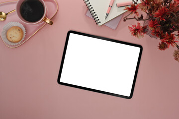 Flat lay digital tablet with blank screen, coffee cup and notebook on pink background