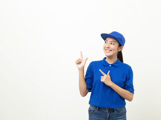Happy delivery asian woman in blue uniform standing pointing the finger to blank space for text advertise on isolated white background. Smiling female delivery service worker.