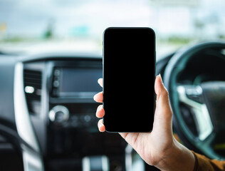 Close up woman hand using smartphone while driving car. Showing blank screen of cell phone in car for application.