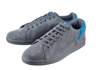 Beautiful pair of fashionable modern sneakers made of gray suede with inserts of bright blue suede in the back, lace-up, isolated on a white background.
