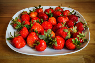 Strawberries on plate, wooden table