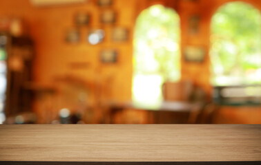 Empty wooden table in front of abstract blurred background of coffee shop . can be used for display or montage your products.Mock up for display of product