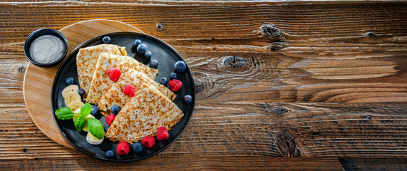 A plate of pancakes with cheese and fruits