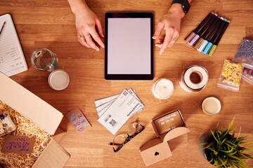 Overhead Shot Of Woman Running Online Business Making Candles At Home Working On Digital Tablet