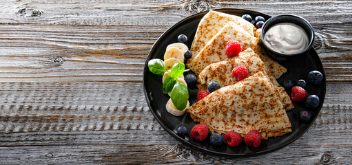 A plate of pancakes with cheese and fruits