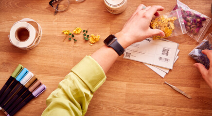 Close Up Of Woman Making Boutique Flower Candles To Sell Online Working From Home