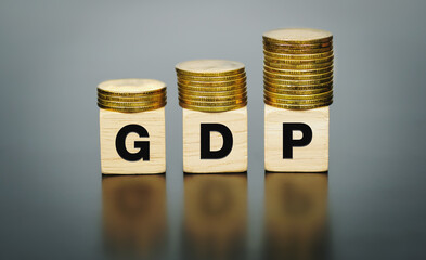 GDP text on a wooden block with coins on top, Business and finance concept.          