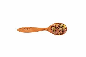 Pistachios in wooden spoon white background, top view. Design element. Peeled Green pistachio