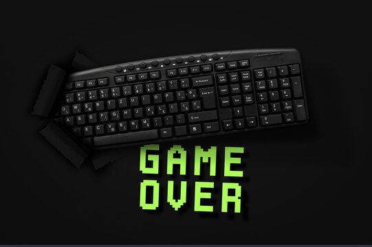 PC keyboard with words Game Over on black background