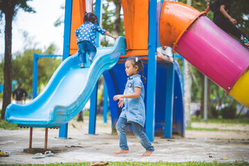 The girls enjoy playing slides in the playground.