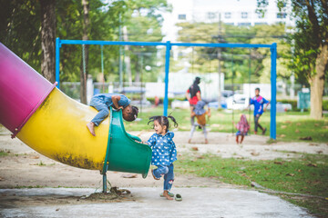 The girls enjoy playing slides in the playground.