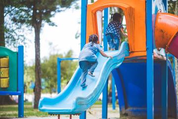 The girls enjoy playing slides in the playground.