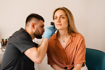 Fototapeta premium Otoscopy of ears with otoscope. ENT doctor. Consultation with otolaryngologist. Treatment of woman ear pain.