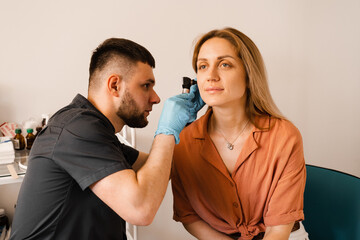 Fototapeta premium Otoscopy of ears with otoscope. ENT doctor. Consultation with otolaryngologist. Treatment of woman ear pain.