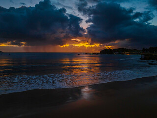 Obraz premium Aerial sunrise at the seaside with rain clouds