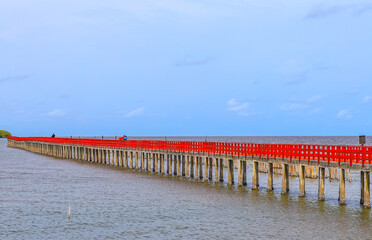 Fototapeta na wymiar Red Boardwalk Bridge near Matchanu Shrine,Phanthai Norasing,Samut Sakhon,Thailand.