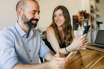 Selective focus. young couple working from their living room in their business. Looking at things on the laptop. Smiling and talking about work.