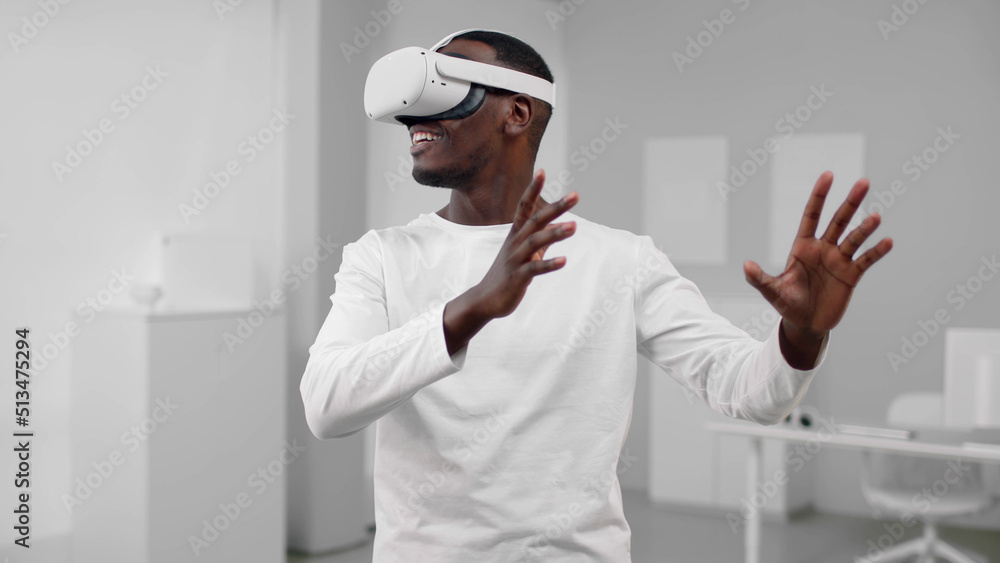 Wall mural Portrait of African-American man in white clothes use augmented reality headset 