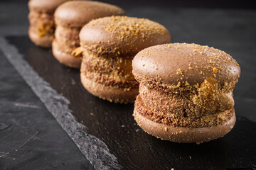 colored macaroons on a dark stone background