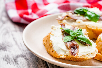 sandwich with anchovy fillet on a tray for serving on a wooden rustic background