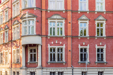 Fototapeta na wymiar Corner of a city tenement house. Richly decorated facade made of red brick. Fragment of the town hall building in Siemianowice, Poland