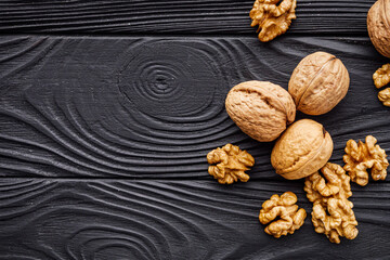 dried walnuts on a black rustic wooden background