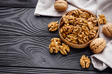 dried walnuts on a black rustic wooden background