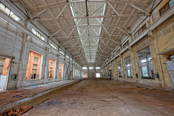 Fototapeta na wymiar Interior of abandoned steel frame workshop factory building in industrial area