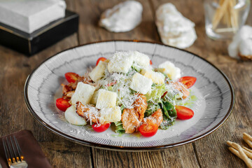 Portion of caesar salad with chicken on wooden table - obrazy, fototapety, plakaty