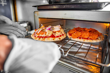 hand of chef baker making mini pizza at kitchen. The process of making pita pizza. cooking italian...