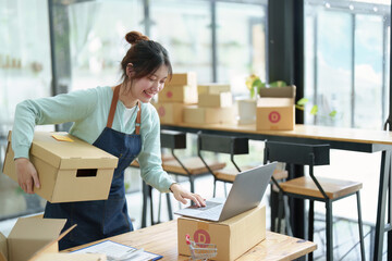 A portrait of a small startup, an SME owner, an Asian female entrepreneur checking orders to...