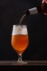 Pouring beer into glass at the bar counter.