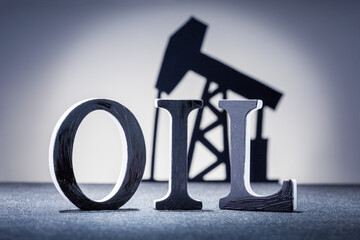  Word OIL with oil pump oh the background. World Oil Industry.