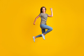Fototapeta na wymiar Fill body portrait of overjoyed delighted girl jump raise fists celebrate success isolated on yellow color background