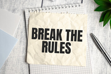 BREAK THE RULES word on the paper with office tools on white background