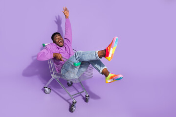 Full length body size view of attractive crazy cheery guy riding cart fooling isolated over vivid violet lilac color background