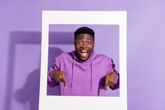 Photo of shocked funny person direct finger down empty space open mouth isolated on purple color background
