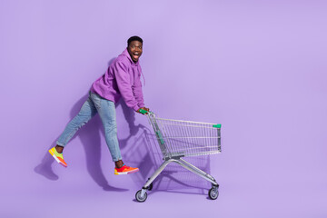 Full length profile portrait of excited crazy handsome guy jump low price offer isolated on violet color background - obrazy, fototapety, plakaty
