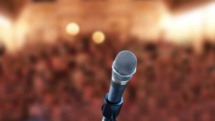 Close up of microphone, with audience in background