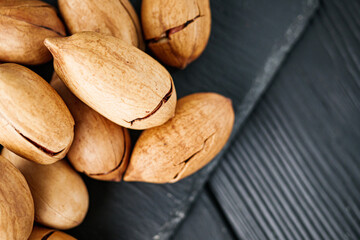 delicious fresh pecans on a black rustic wooden background