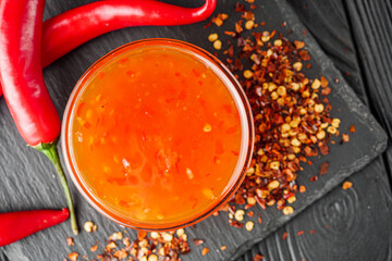 sweet chili sauce on a black wooden rustic background