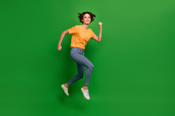 Full length profile photo of sportive charming person running jump isolated on green color background
