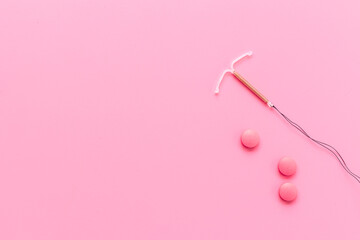 Obraz na płótnie Canvas Contraception concept. T-shaped intrauterine contraceptive with medicine pills