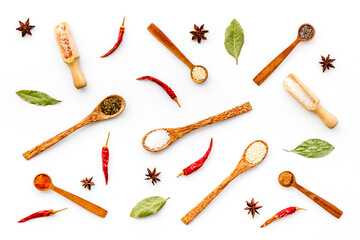 Cooking background with colorful spices and herbs in wooden spoons, top view