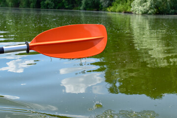 Paddle from a kayak with water drops close-up against the background of river water