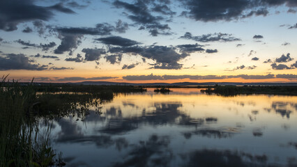 Landscape a large lake with circles on the water in the rays of the setting sun.